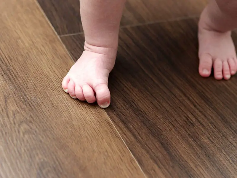 Baby Feet On Wooden Floor